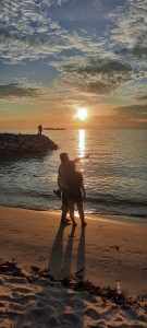 a couple standing on a beach in sunset