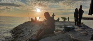 a man fishing in sunset