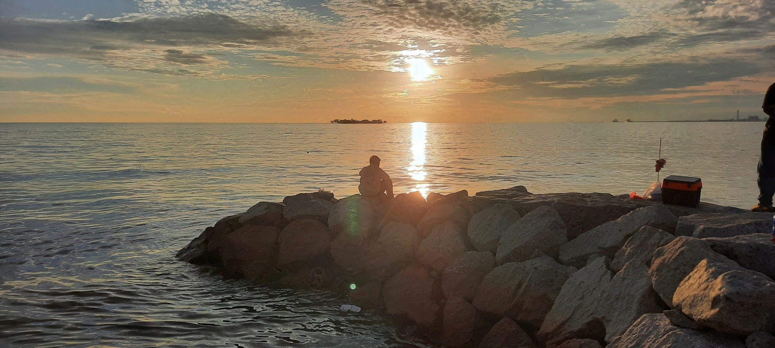 a man fishing in sunset